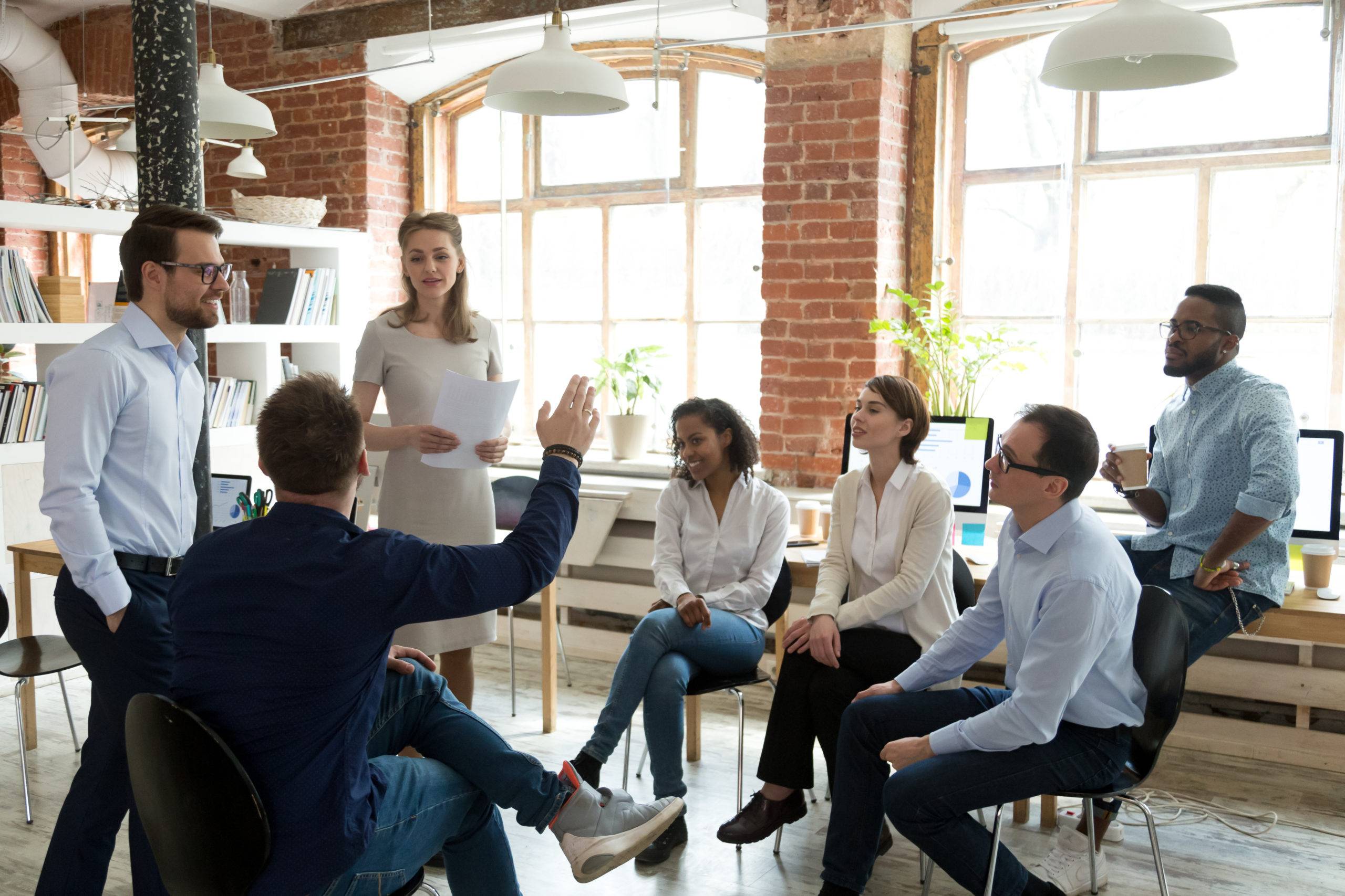 Male worker raise hand asking question at office teambuilding